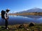 Man, hiking in the Andes Mountains in Peru, with a mountain\'s reflection in the Huascaran lake