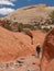 Man hiking in narrow red sandstone canyon