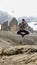 Man in hiking outfit jumping in front of the famous Tre Cime di Lavaredo (Drei Zinnen), mountains in Italian Dolomites.