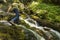 Man hiking over waterfall with motion blur.