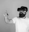 Man with hipster beard in VR glasses using digital touch screen. Bearded man interacting with cyber space through