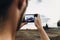 man hipster traveler taking photo holding smart phone, of beautiful sunset scenery in summer field. instagram photography.