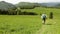 Man with his beagle dog runs down green mountain valley