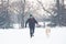 Man and his beautiful dog akita walking on snow. Winter concept