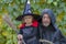 A man and his daughter dressed as a monk and a witch on Halloween, a family holiday.