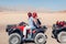Man and his daughter driving quad bike in Sinai desert. Happy family having fun during summer vacation