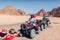 Man and his daughter driving quad bike in Sinai desert. Happy family having fun during summer vacation