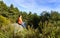 Man with his face to the sun in the mountains, sitting on a rock, on a cold spring morning