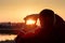 Man with his hands shows a cropping gesture composition on the background of a sunny sunset