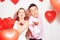 Man with his lovely sweetheart girl dance and have fun at Lover`s valentine day. Valentine Couple Party. Background red balloons