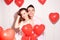 Man with his lovely sweetheart girl dance and have fun at Lover`s valentine day. Valentine Couple Party. Background red balloons