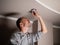 A man with his own hands replaces a failed LED lamp. Energy saving.