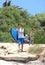 Man and his son arriving at the beach to surf