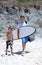 Man and his son arriving at the beach to surf