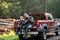 Man at his truck with his son in the forest. Hunter teaches young boy how to use shotgun rifle.