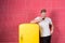 Man hold cup of tea or coffee in kitchen. Macho drink at retro fridge on pink background. Bachelor with morning drink at refrigera