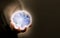 Man hold glowing world globe in dark