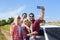 Man hold smart phone camera taking selfie photo friends smile countryside car