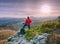 Man hold tripod. Hiker admiring stunning mountain range