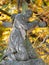 The man hold wooden cross, graveyard statue. Heloween walk in old town graveyard