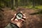 Man holding antique vintage style compass in hand in middle of fir tree forest with nice natural light