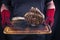 Man is holding Barbecue Wagyu Tomahawk Steak on old burnt cutting board in his hands