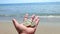 Man holding Bitcoin BTC coins hand background sea waves sandy beach sea shore