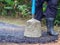 Man holding a cement rod for hammering to adjust the asphalt surface for the walkway. Close-up photo. Constructed from asphalt.