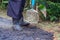 Man holding a cement rod for hammering to adjust the asphalt surface for the walkway. Close-up photo. Constructed from asphalt.