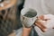 Man holding a ceramic cup of water. Cup of purified water holding in hand.