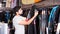 man holding and choosing suit for surfing in the shop