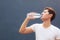 Man holding clean fresh mineral water bottle with court background, drinking water outdoor under summer heat. Health care