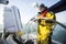 Man Holding Coffee Cup While Standing At Helm Of Sail Boat