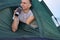 Man holding coffee cup in tent in morning enjoying the leisure. Concept of travelling, hiking, camping