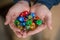 Man Holding Colorful Polyhedral Dice in His Hands