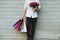 Man holding colorful shopping bag & red rose bouquet outdoors. s