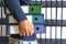 Man holding, corporate files in document binder.