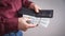 Man holding dollars with wallet standing over grey background