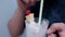 Man holding and drinking tasty vanilla milkshake with straw