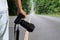 Man holding dslr digital camera on blurred straight road in national park background