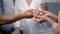 Man holding fiancee hand with engagement ring, showing to mother, happy family