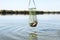 Man holding fishing net with catch over river