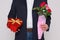 Man holding flowers and a box of chocolates