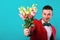 Man holding flowers on Valentine`s Day, turquoise background