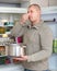 Man holding foul food near fridge