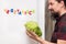 Man holding a fresh salad, fridge with german word, vegetarian