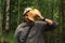 Man holding giant milk agaric in front of his face after picking them in forest on a autumn day