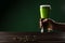 Man holding glass of green beer above table with coins, st patricks day concept