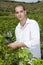 Man holding a glass of wine in a vineyard