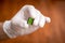 Man holding a green microchip with disposable gloves, hands only. extreme close-up.